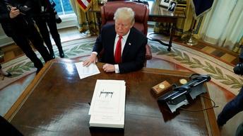 News Wrap: Trump signs GOP tax bill into law