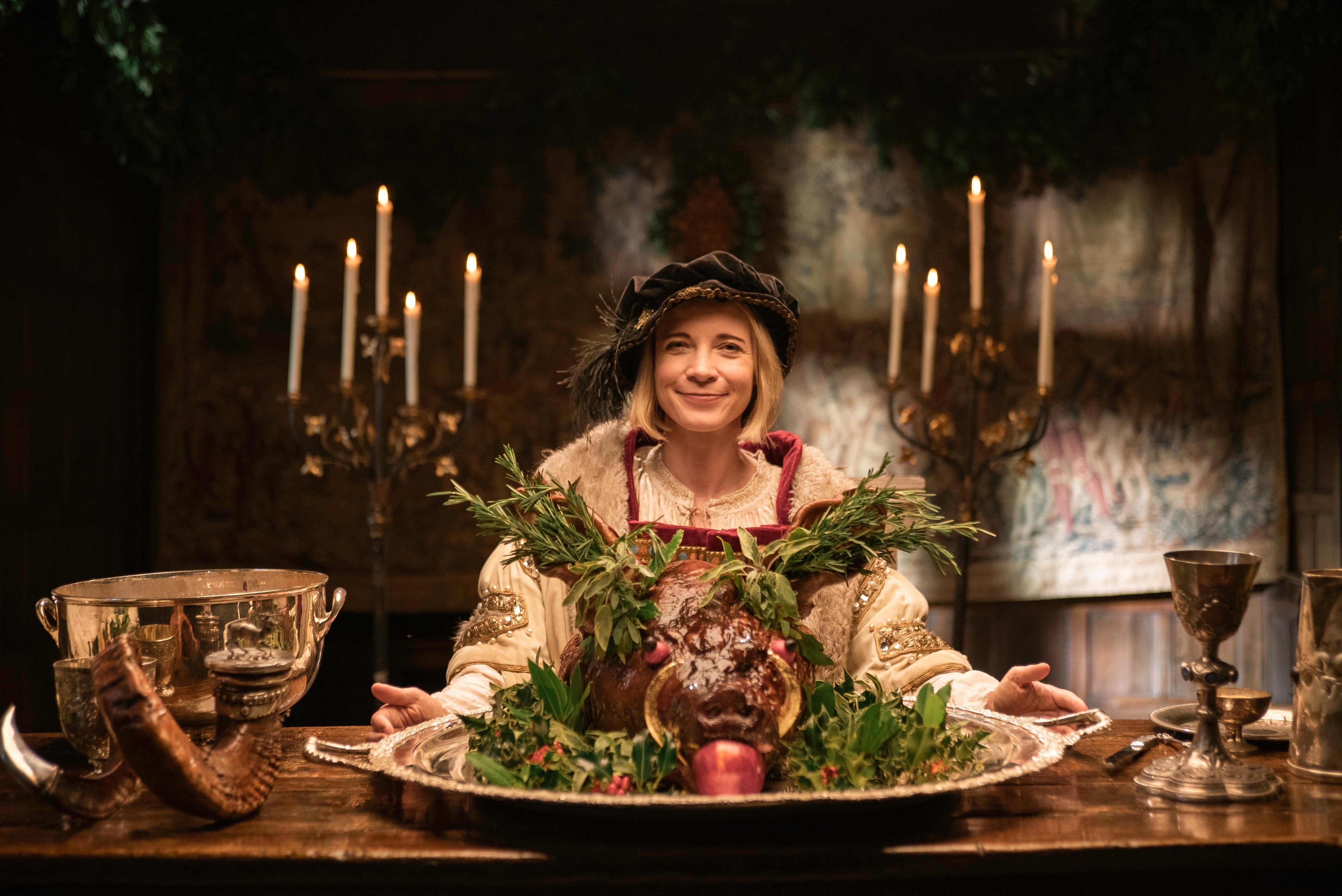 Lucy Worsley in Henry VIII costume with boar's head.
