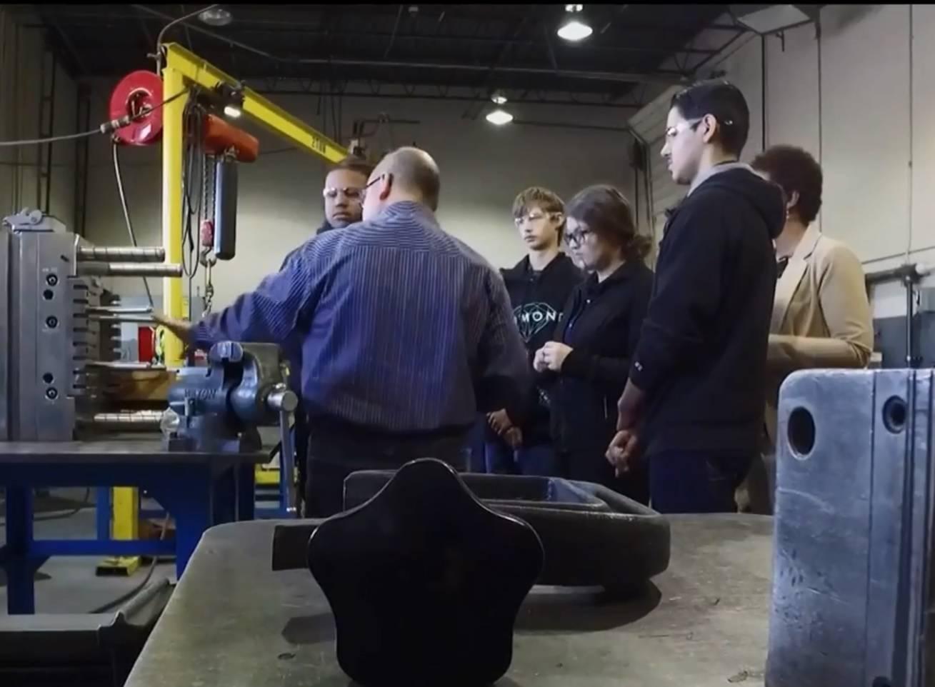 Students gather around equipment in a classroom