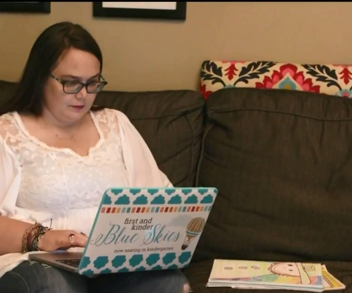 A teacher looks at her laptop.