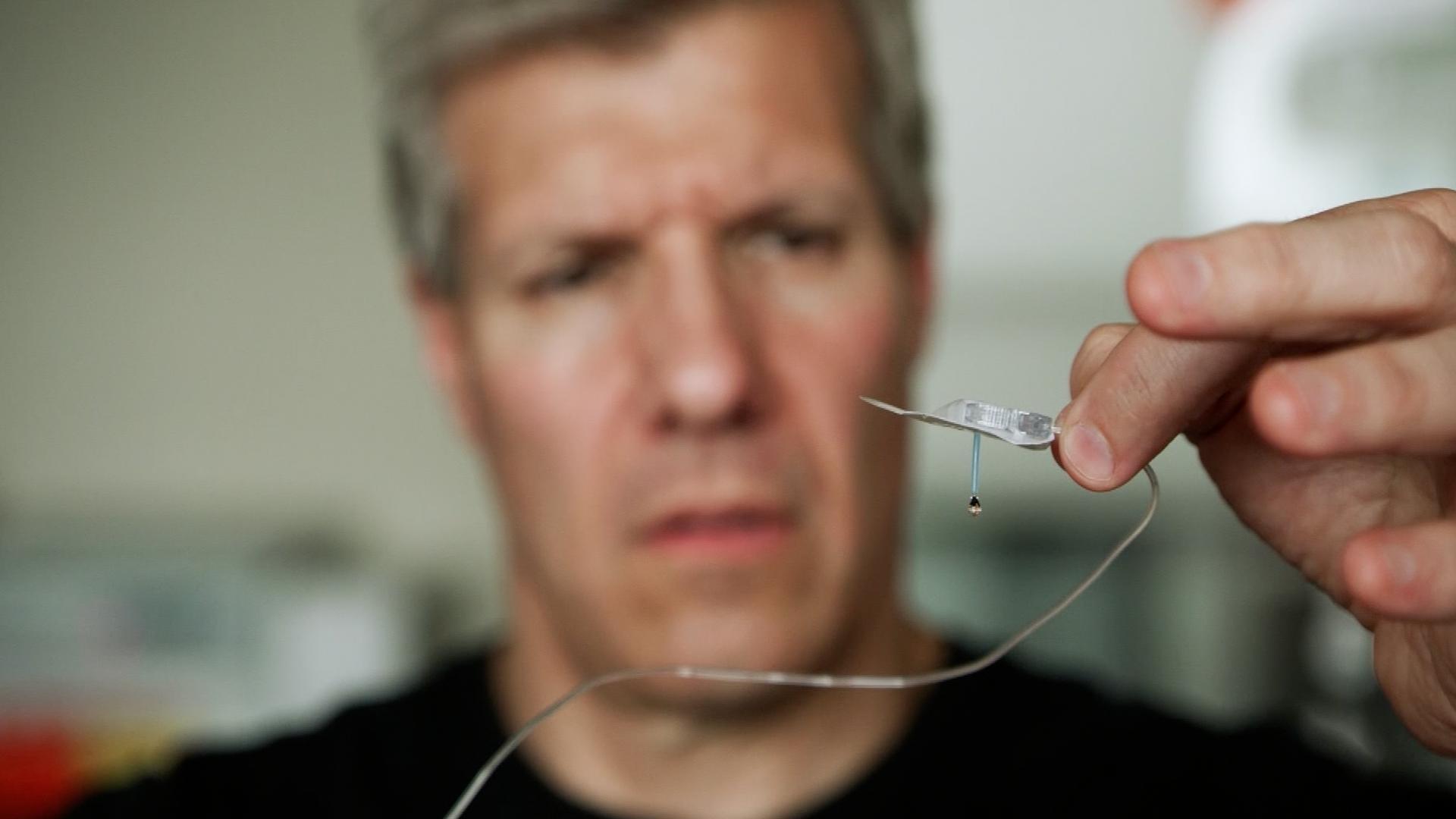 A close-up of Ed Damiano holding up a medical device. Part of his work towards creating a bionic pancreas.