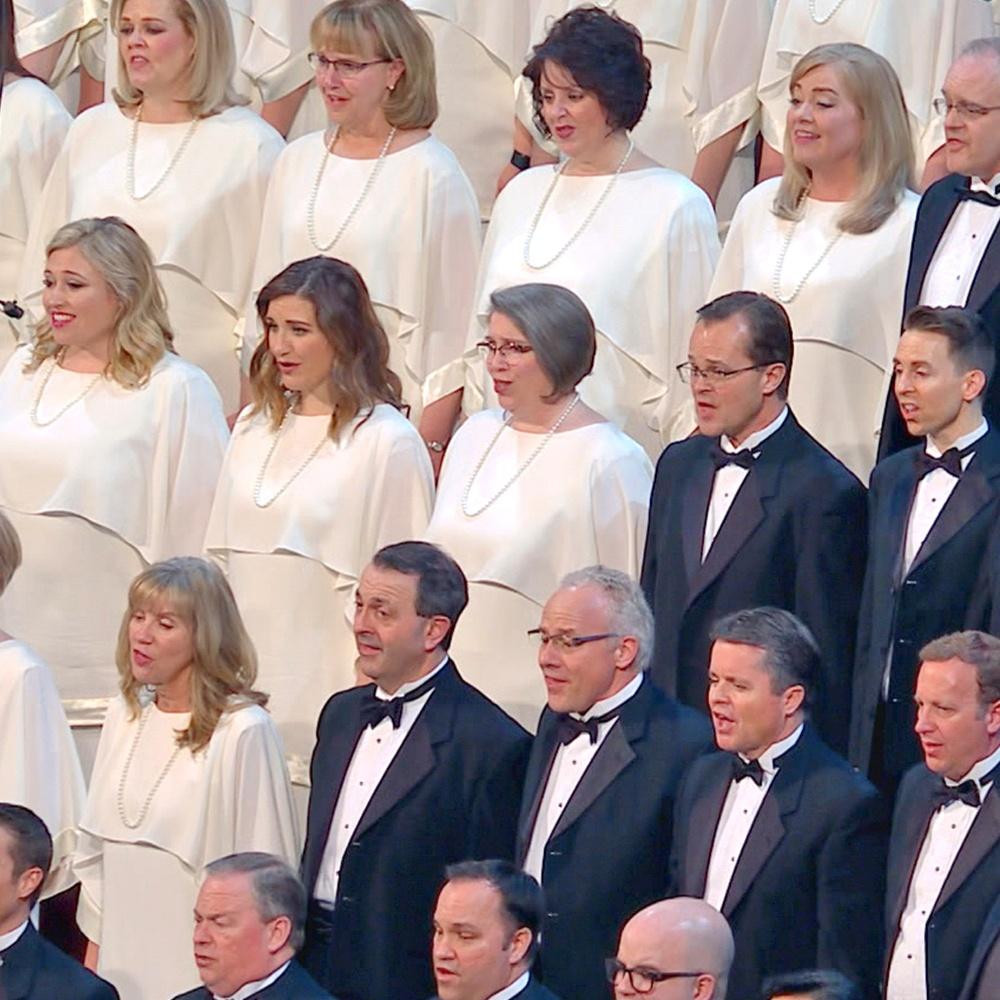 Dressed in dark suits and white dresses, The Tabernacle Choir sings For unto Us a Child is Born.