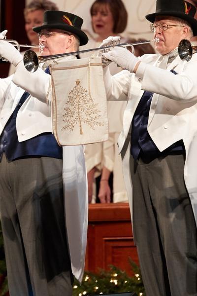 Trumpet players dressed in white coats and top hats play Hark! The Herald Angels Sing.