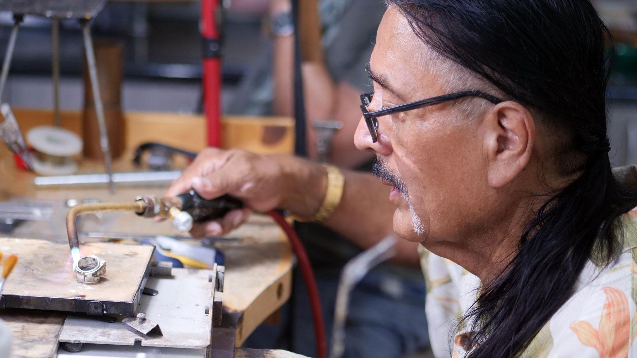 Navajo/Hopi jewelry artist Jesse Monongya torches silver at his jeweler's bench