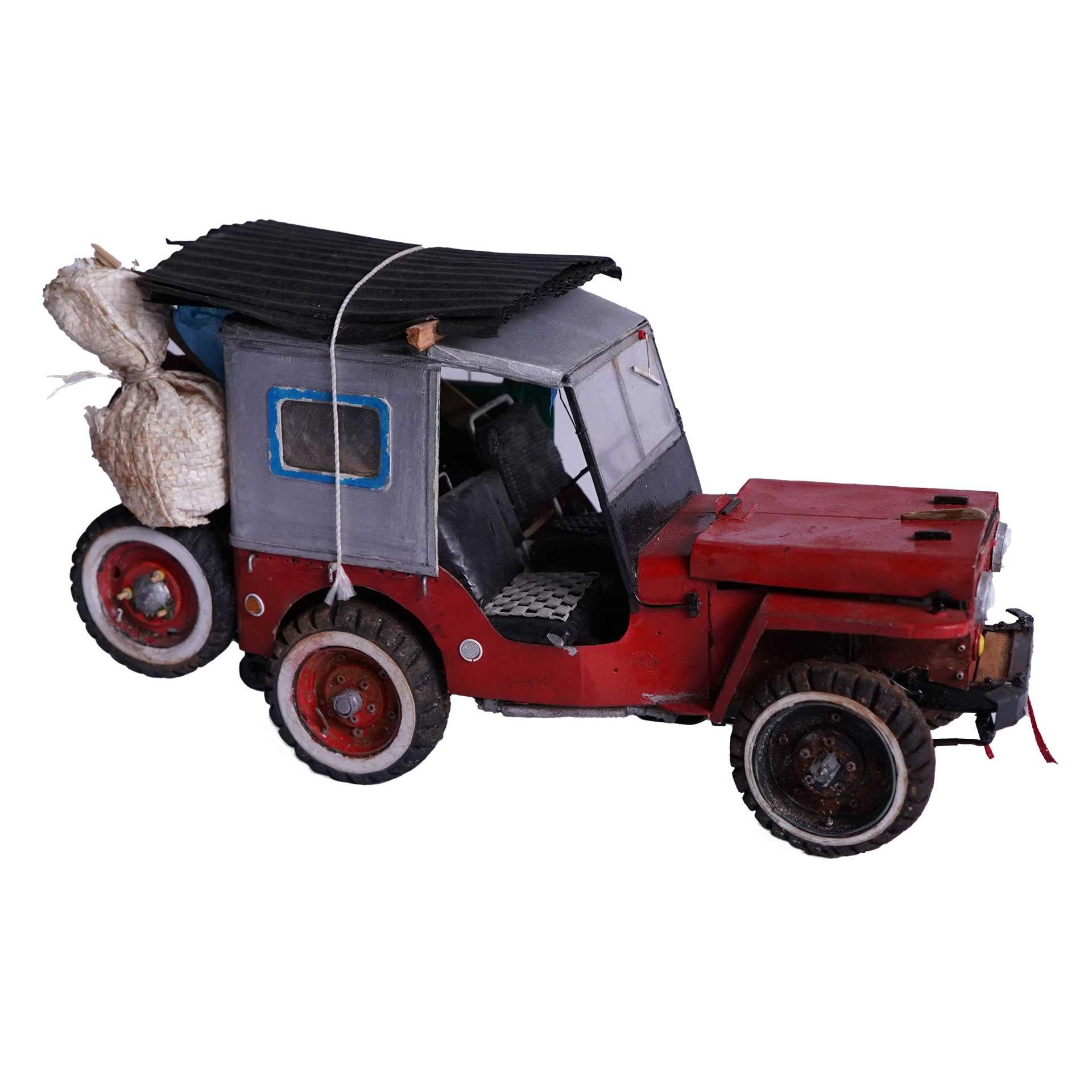 Leandro Gomez Quintero, small scale model of a red Willys Jeep with sacks in the back and roofing material on the top of the vehicle strapped down