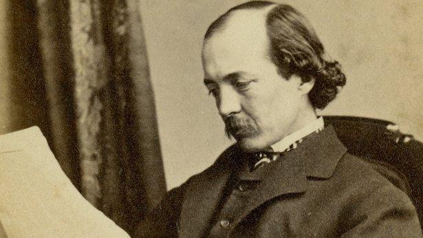 Photograph of Frederick Law Olmsted reading a piece of paper.