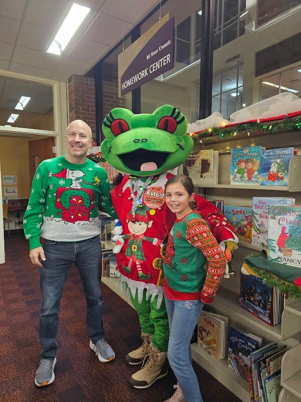 Guardian and girl showing off their sweaters while posed next to Ruby the Frog.