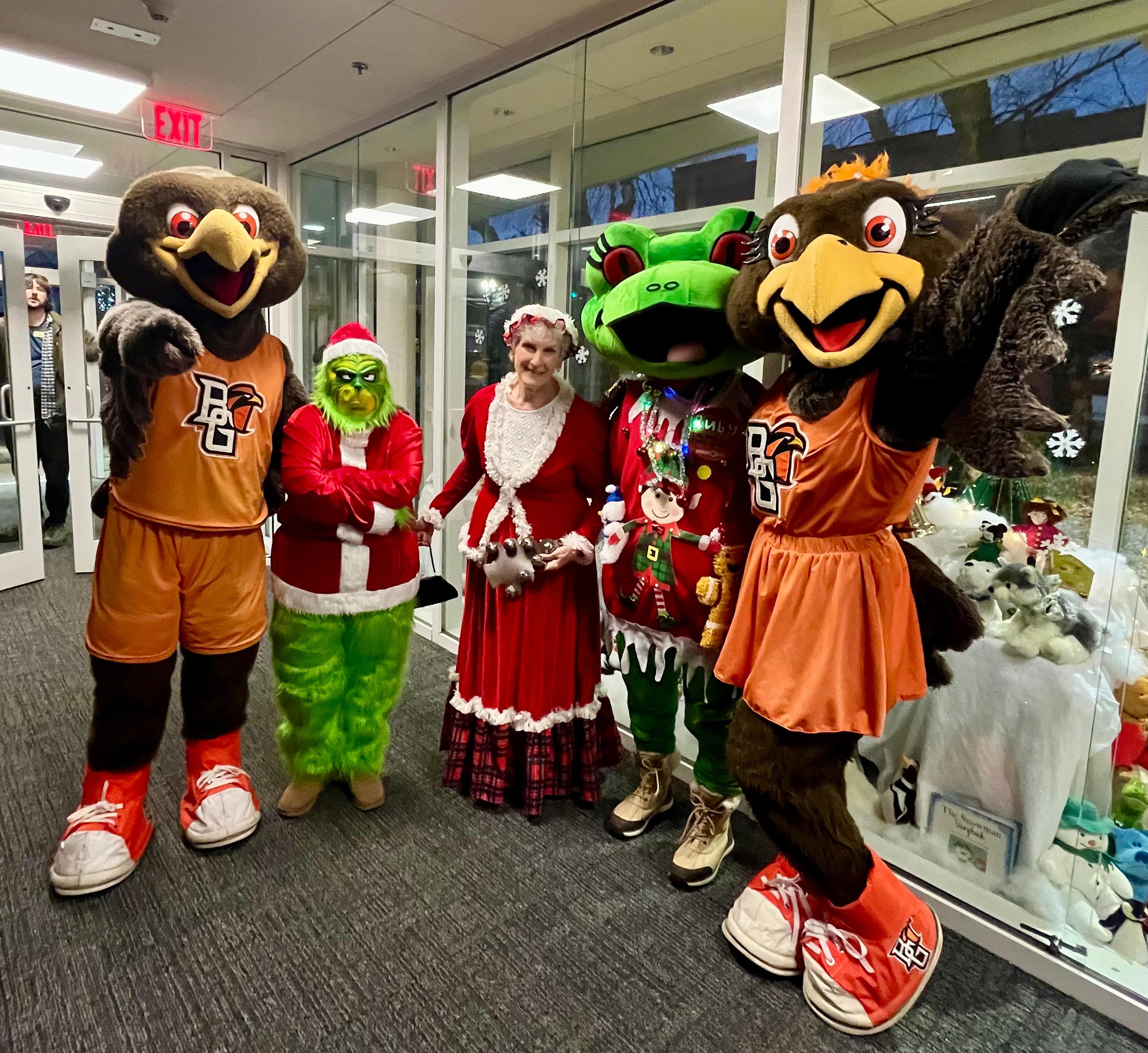 Freddy, Frieda, Ruby the Frog, the Grinch, and Mrs. Claus all smiling next to each other.