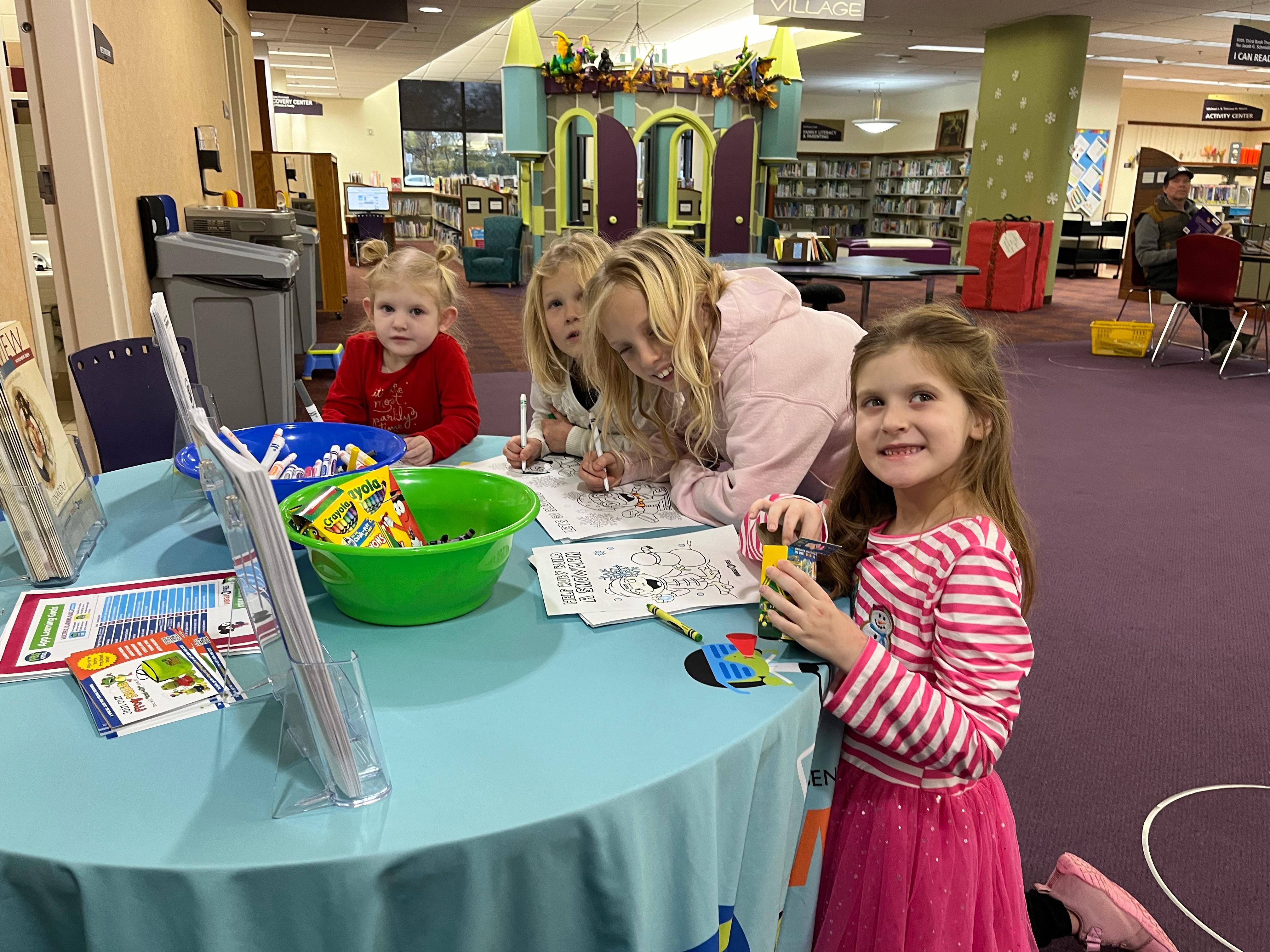 A group of four girls working on Ruby coloring pages at a round table.