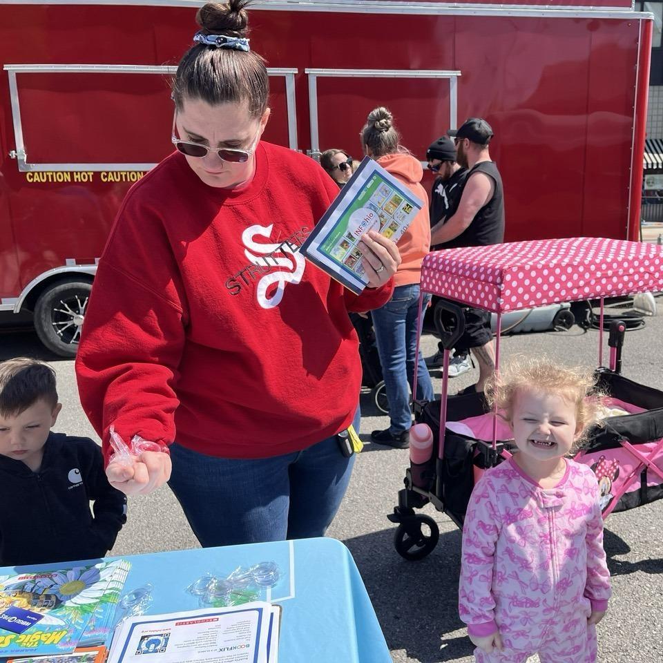 May 9, 2026 - A family holds an INFOhio BookFlix Flyer and children's books they received at the Defiance Lilac Festival in Defiance, Ohio. 