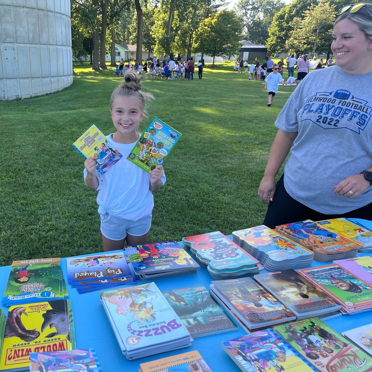 Two girls create magic scratch bookmarks at WBGU's table at the Wayne Public Library Community Event on July 23, 2025.