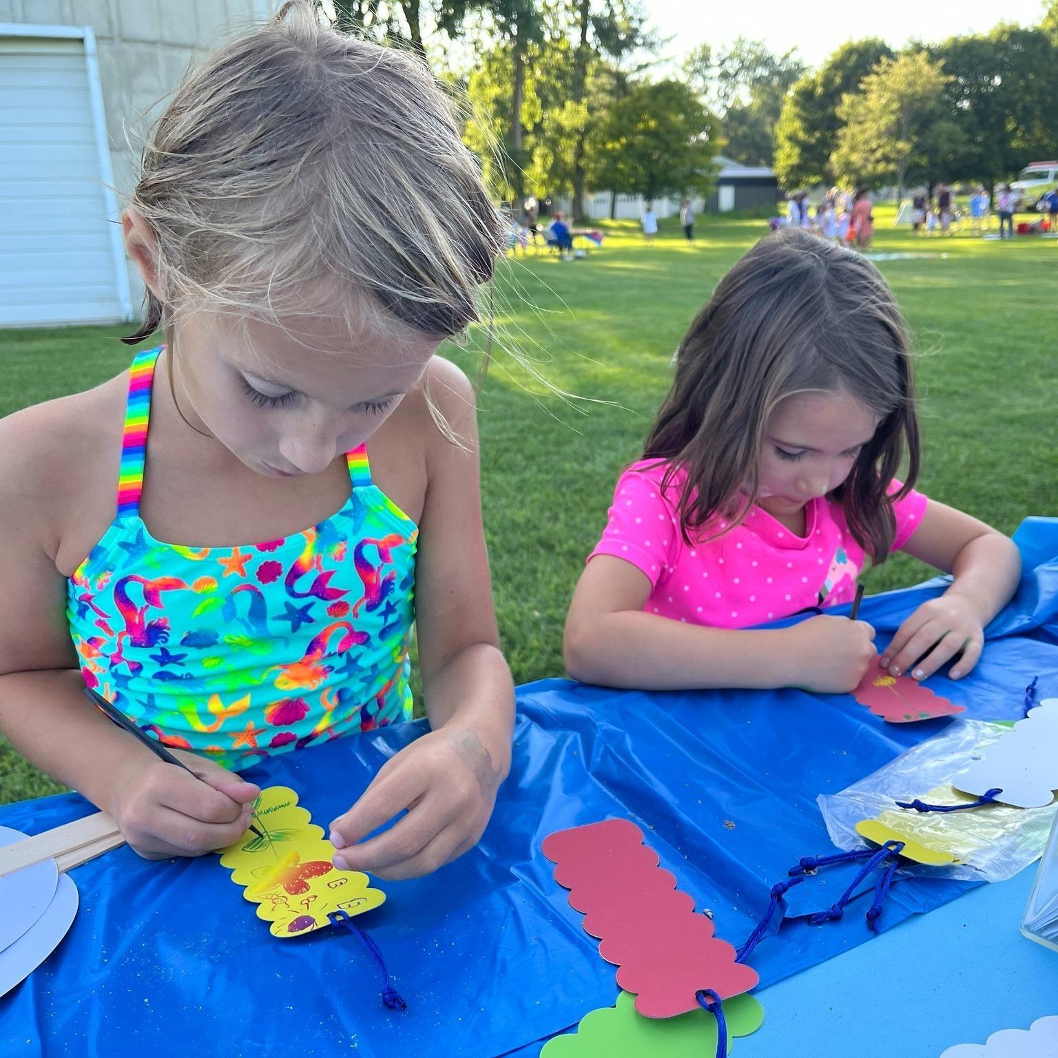 Two girls create magic scratch bookmarks at WBGU's table at the Wayne Public Library Community Event on July 23, 2025.