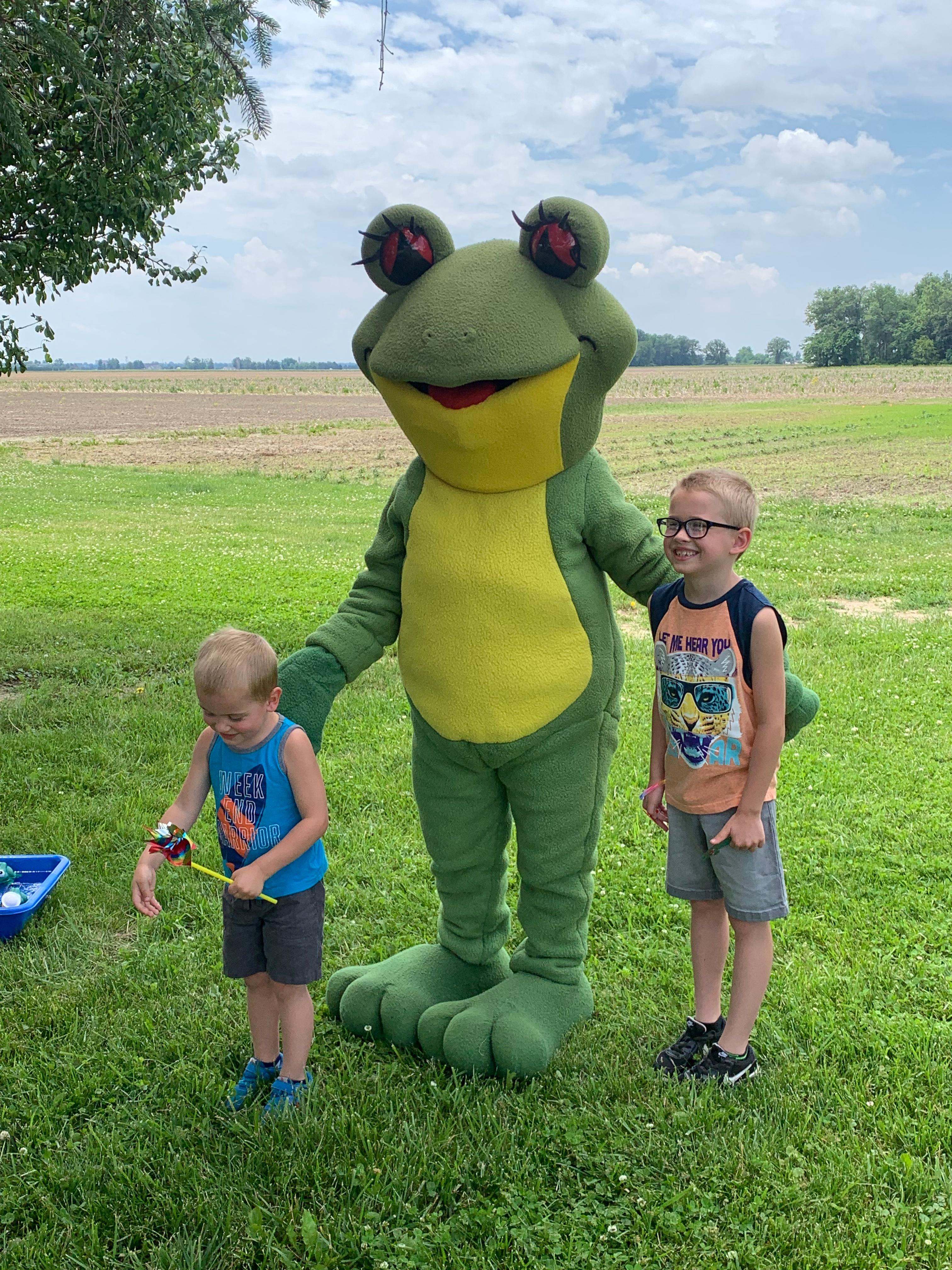 Ruby the Red Eyed Tree Frog mascot with two kids