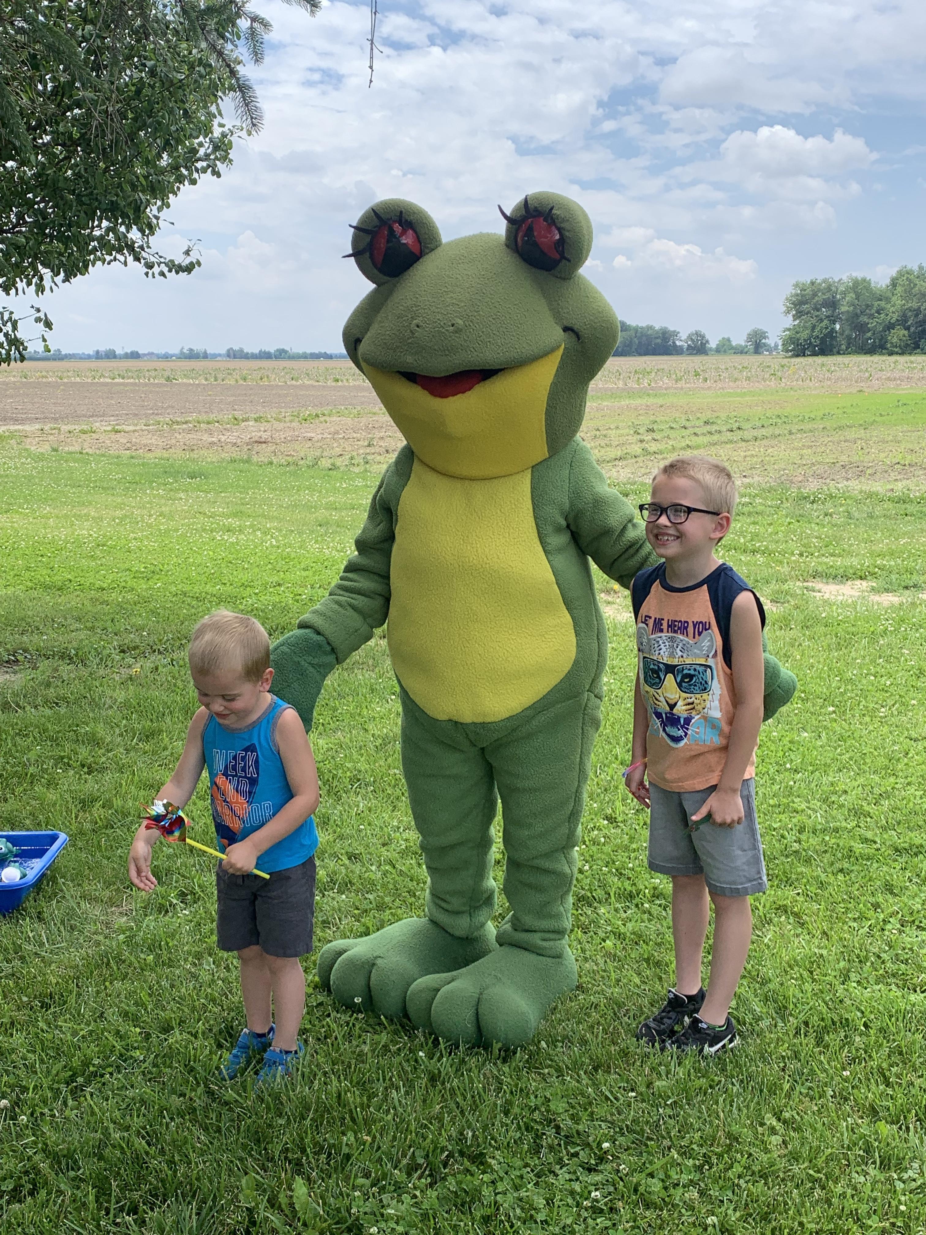 Ruby the Red Eyed Tree Frog mascot with two kids