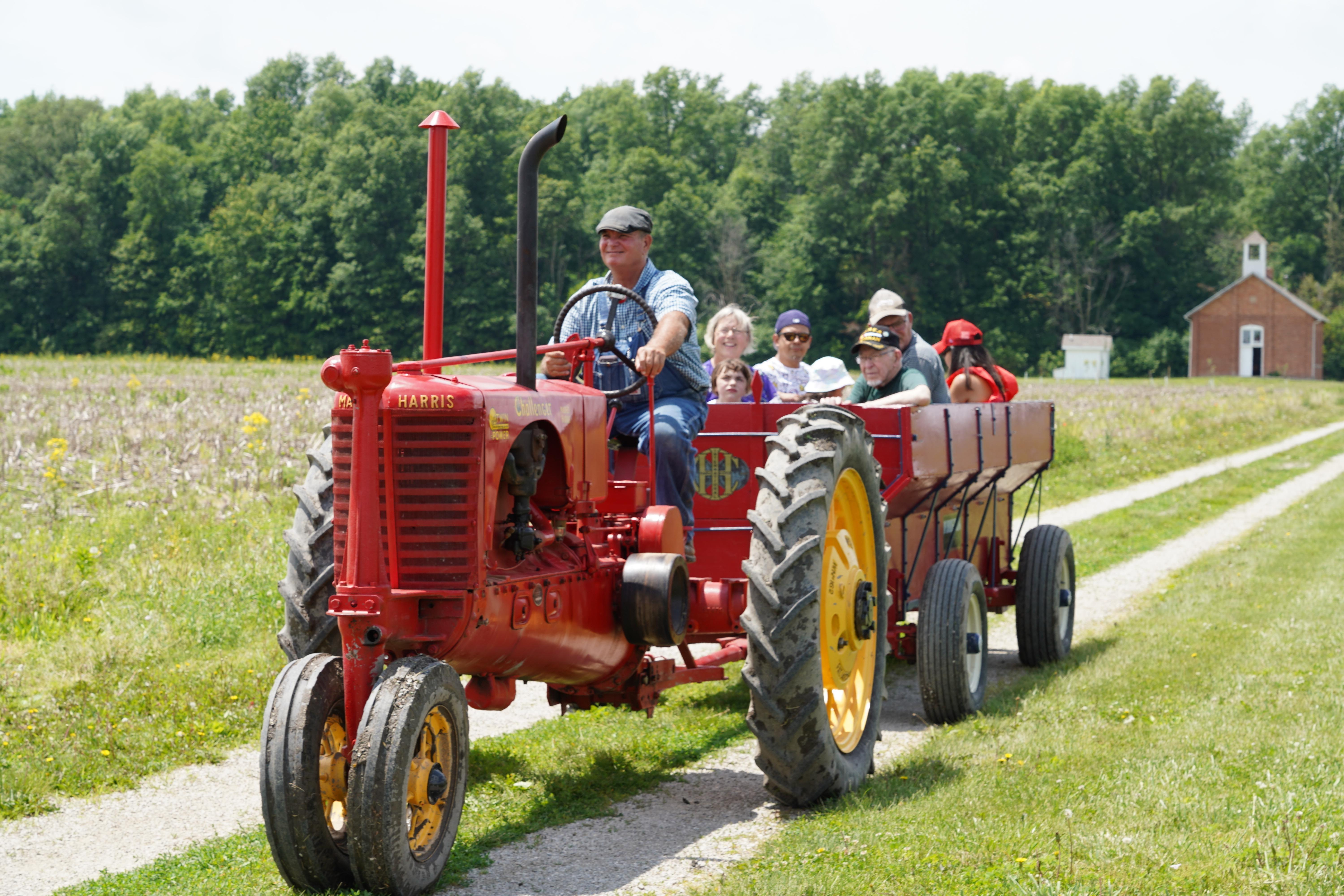 farmer on red tractor pulling trailer