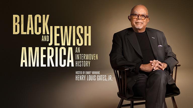 A promotional image for the documentary series "Black and Jewish America: An Interwoven History", featuring host Henry Louis Gates Jr. sitting in a chair. 