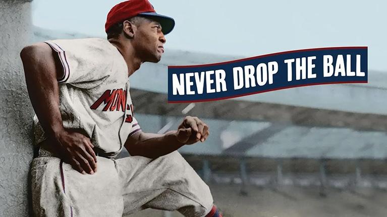 This image is a promotional graphic for a documentary titled "Never Drop the Ball," focusing on the legacy of Black baseball players during segregation. The image features iconic baseball figure Buck O'Neil. 