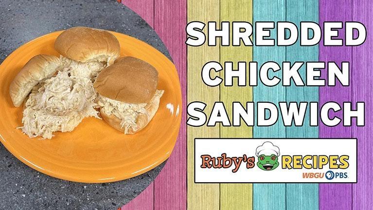 An orange plate holds three shredded chicken sandwiches on soft white buns, set against a dark gray countertop. To the right, a colorful background of vertical pink, yellow, blue, and purple wood planks features the large white text "SHREDDED CHICKEN SANDWICH." Below the text is a white logo for "Ruby's Recipes" featuring a cartoon frog wearing a chef's hat, alongside the WBGU PBS logo.