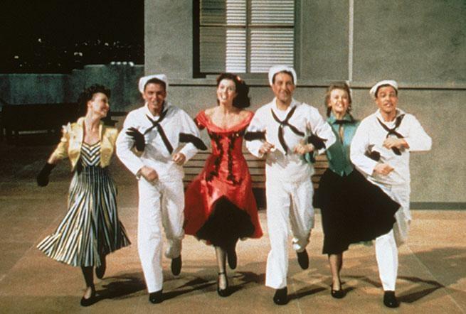 This image is a promotional still from the 1949 MGM musical film On the Town. The photo features (from left to right) Betty Garrett, Frank Sinatra, Vera-Ellen, Gene Kelly, Ann Miller, and Jules Munshin.