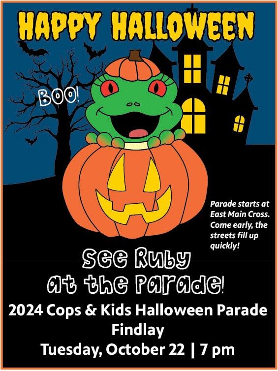 This is a cartoon image of Ruby the Red-Eyed Tree Frog in a Jack-O-Lantern in front of a black background with a dark blue sky. The background picture includes a black haunted house with yellow window, a black tree without leaves and 3 black bats flying around the tree. White text on the image says, Happy Halloween in yellow spooky letters at the top of the image. It also says Boo! in white text next to the frog's head. Finally, the picture include information about the parade that says, See Ruby at the Parade! 2024 Cops & Kids Halloween Parade, Findlay, Tuesday, October 22 at 7 pm. Parade starts at East Main Cross. Come early, the streets fill up quickly! 