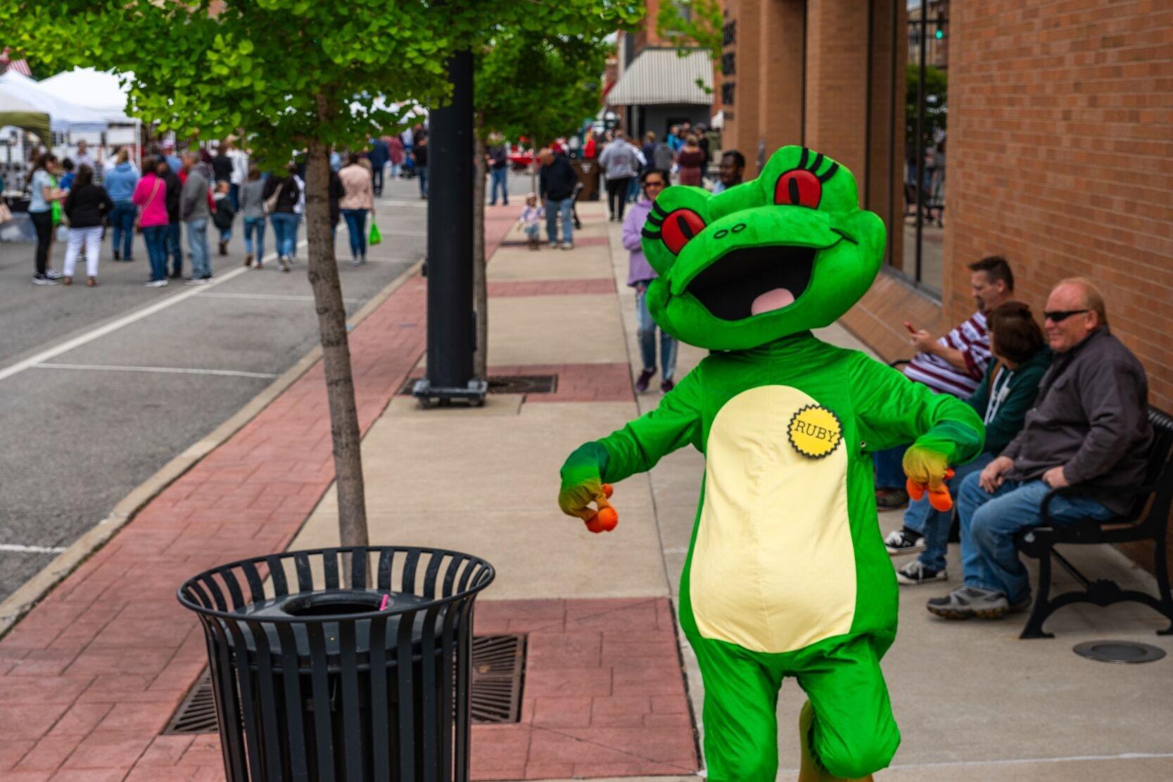 Station mascot Ruby the Red-eyed Tree Frog running