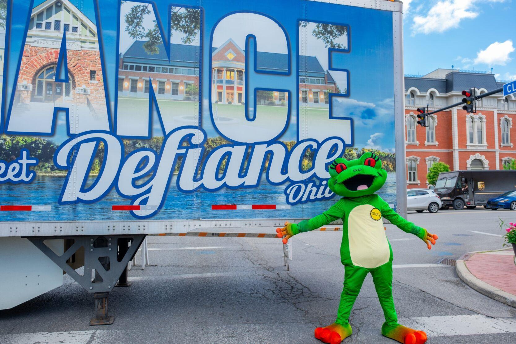 Station mascot Ruby the Red-eyed Tree Frog in front of Defiance Ohio mural