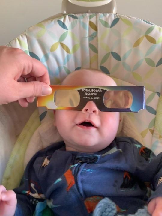 Baby wearing solar eclipse glasses