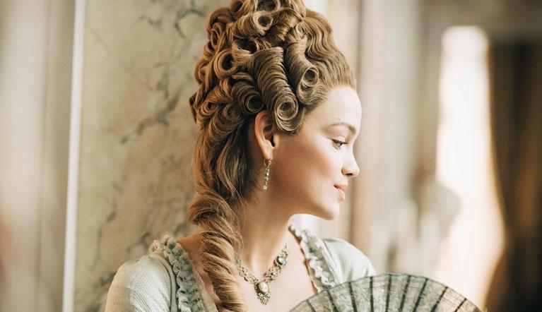 Actress dressed as Marie Antoinette looking out window