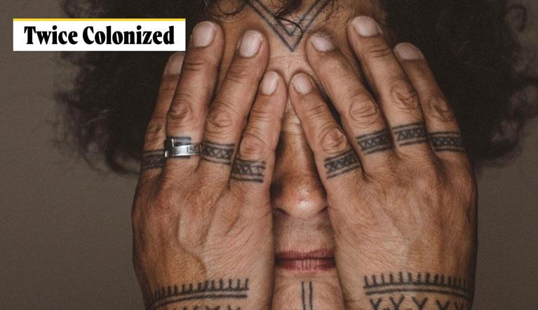 Inuit woman covering her face with her tattoedhands