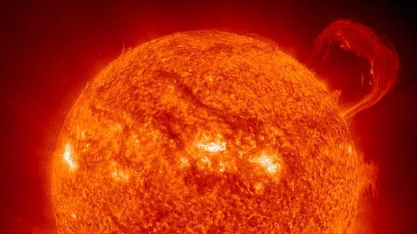 close-up of the sun with a solar flare at the top right