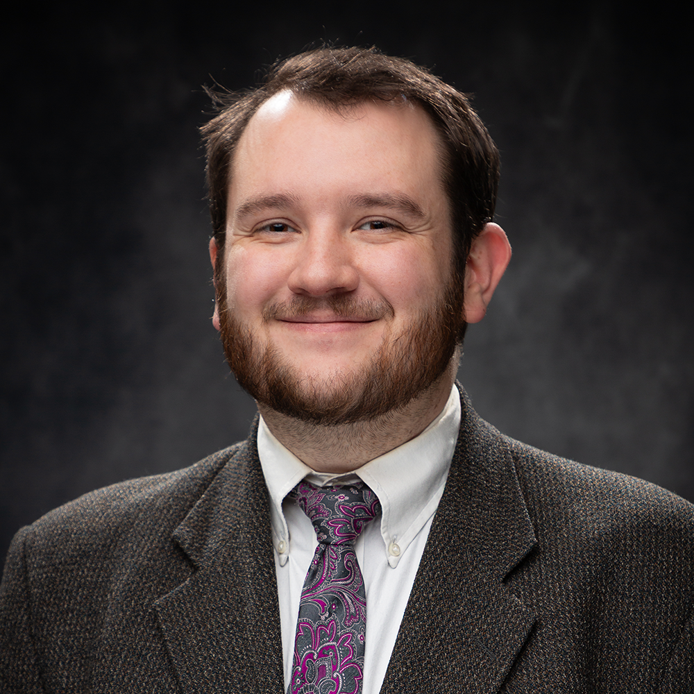 Image of Logan Finney smiling against a gray background