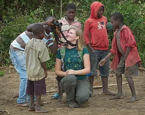 Heidi Ware lets young children look through her binoculars in Gorongosa