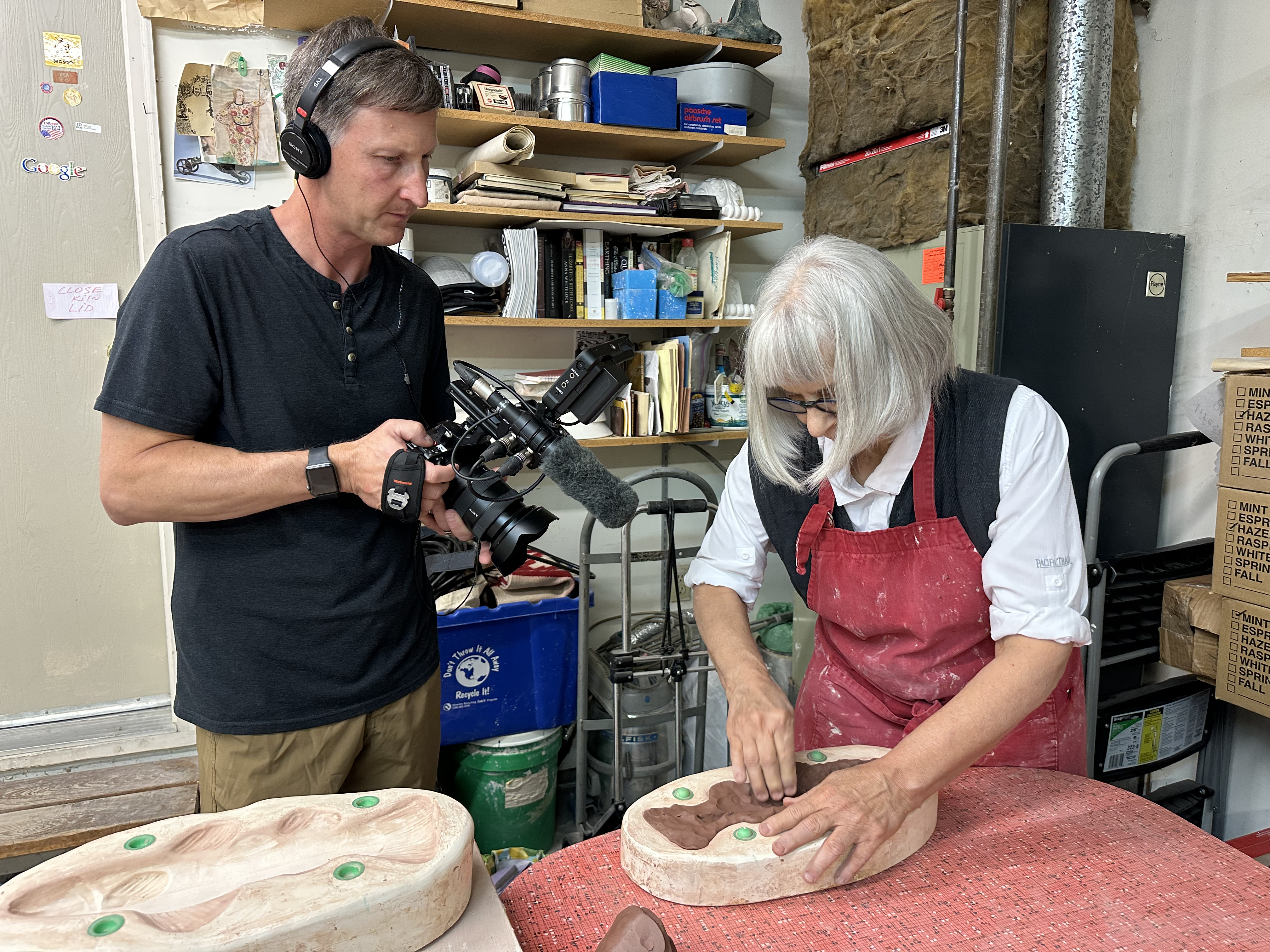 Videographer Troy Shreve filming Lysohir work clay into fish molds