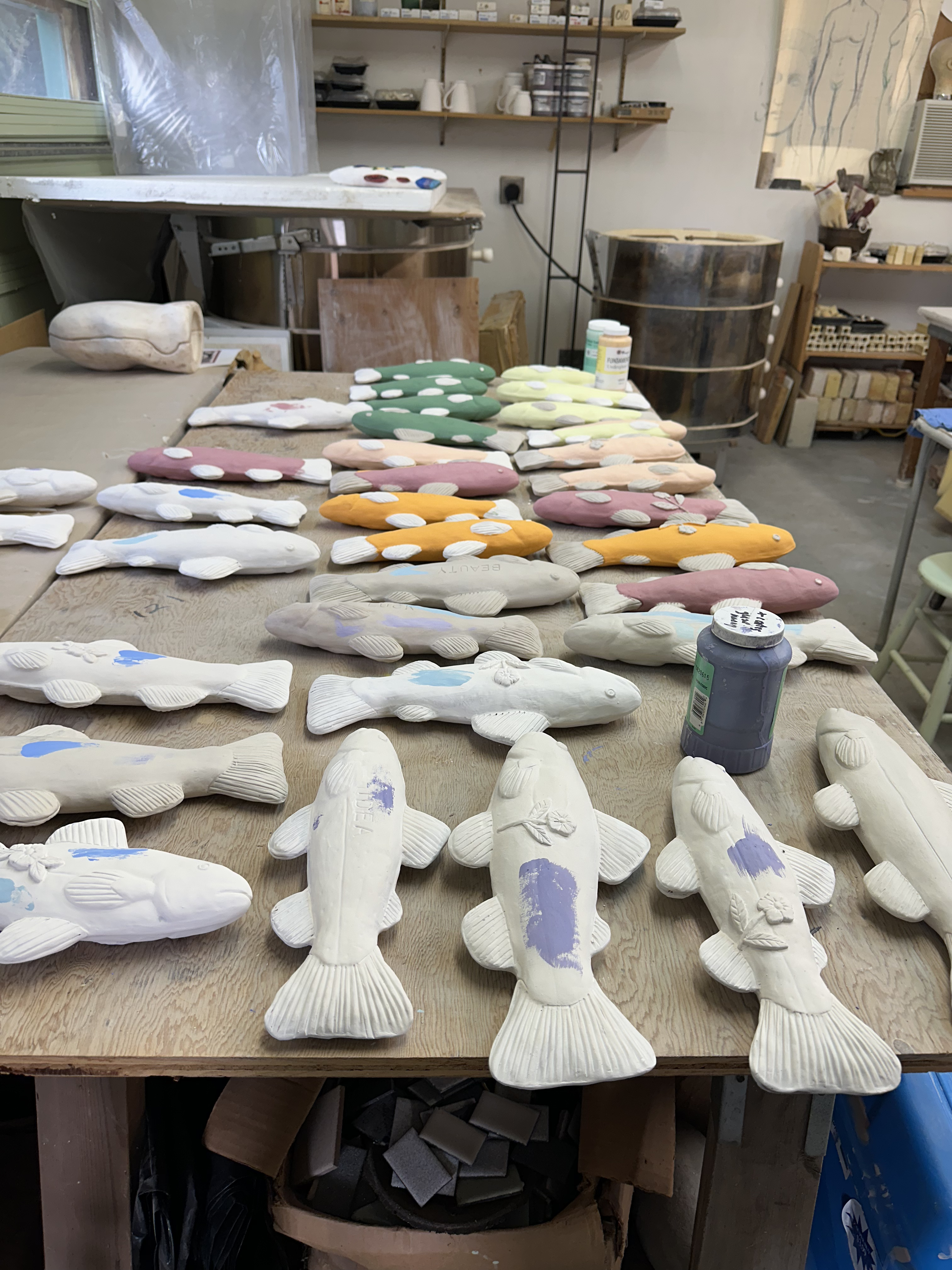 Numerous fish sculptures prepared to be glazed and fired
