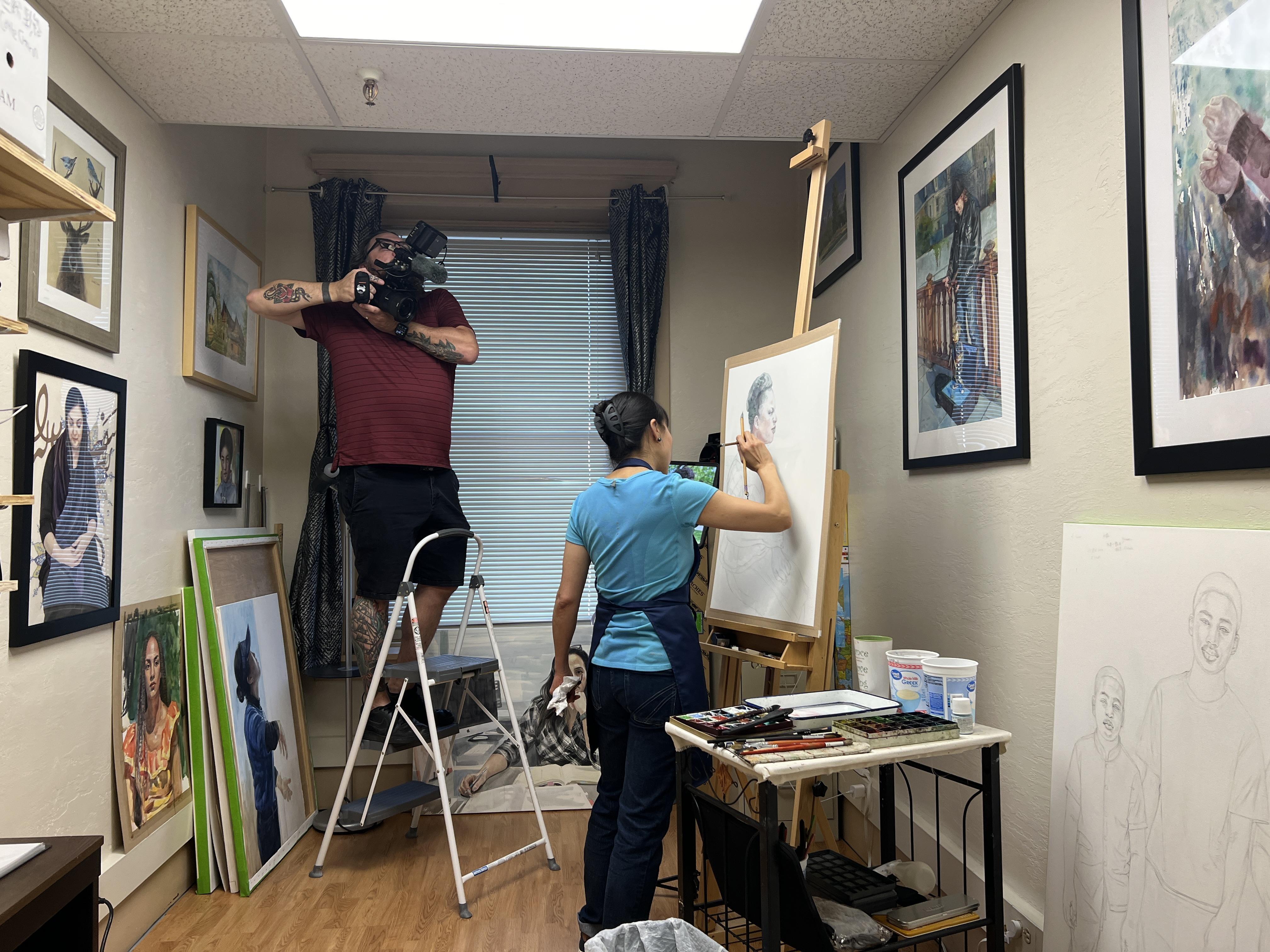 Morgan on a ladder filming Yidan painting Judith