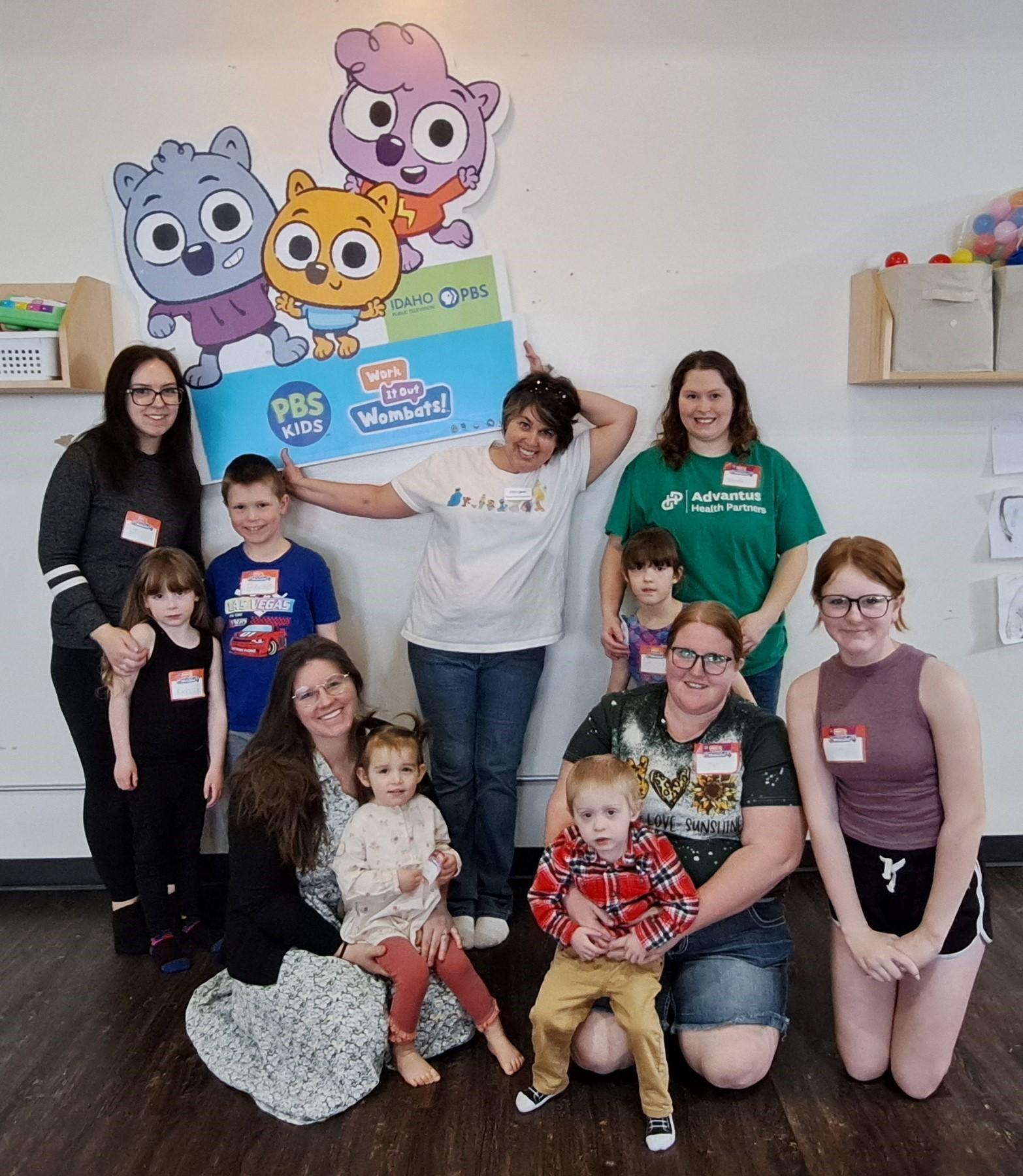 A group of kids in front of a cartoon standee