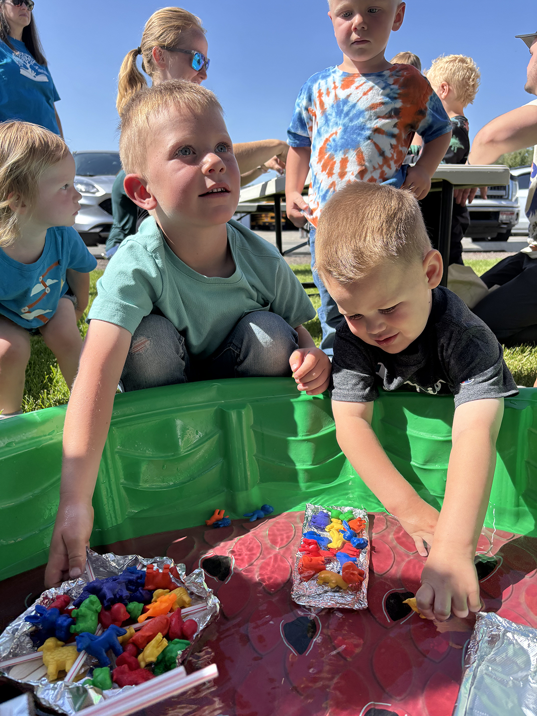 Kids playing in a kiddie pool filled with toys