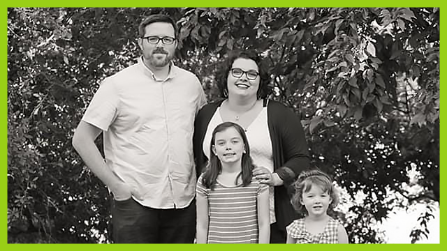 Family standing next to a tree