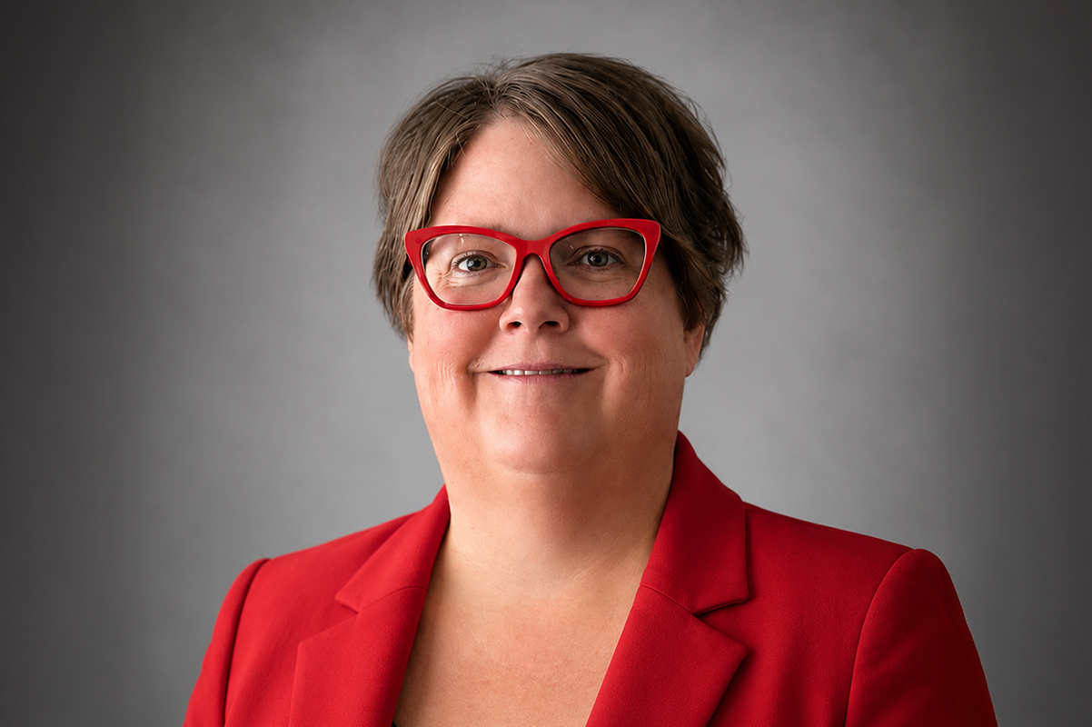 Education Director Kari Wardle, wearing a red blazer, short brown hair and red glasses