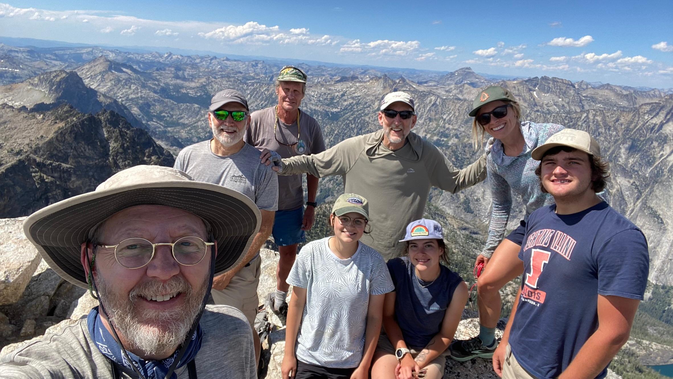 Jay Krajic, Bill Manny, Lauren Melink and group smiling on top of the mountain