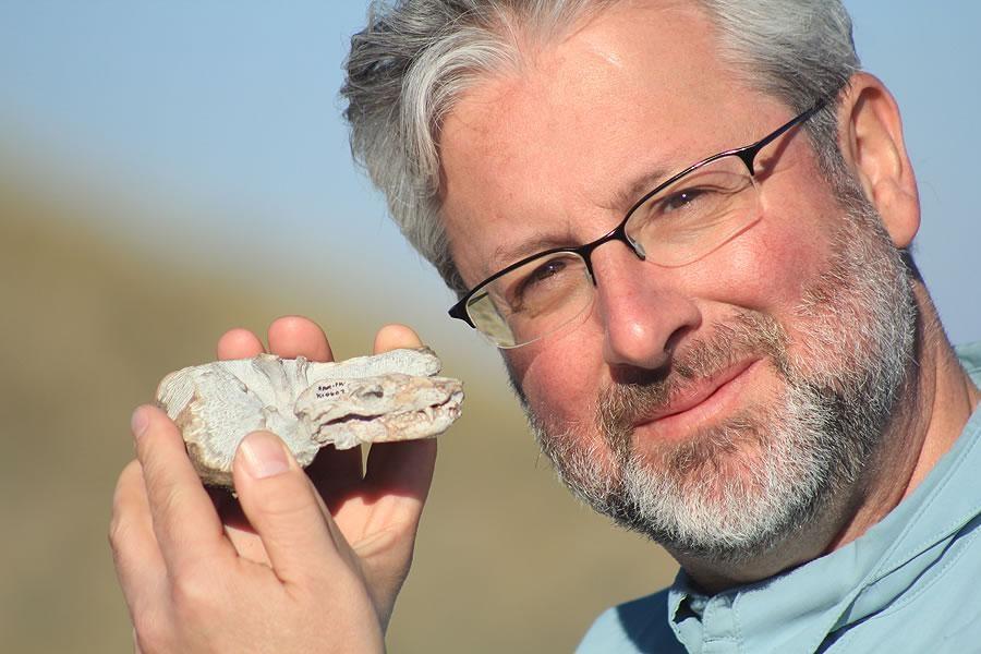 Neil Shubin holding up a Thrinaxodon fossil