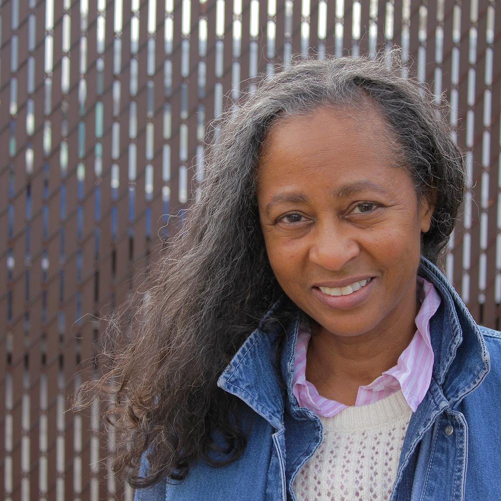 Photo of a woman in front of a fence