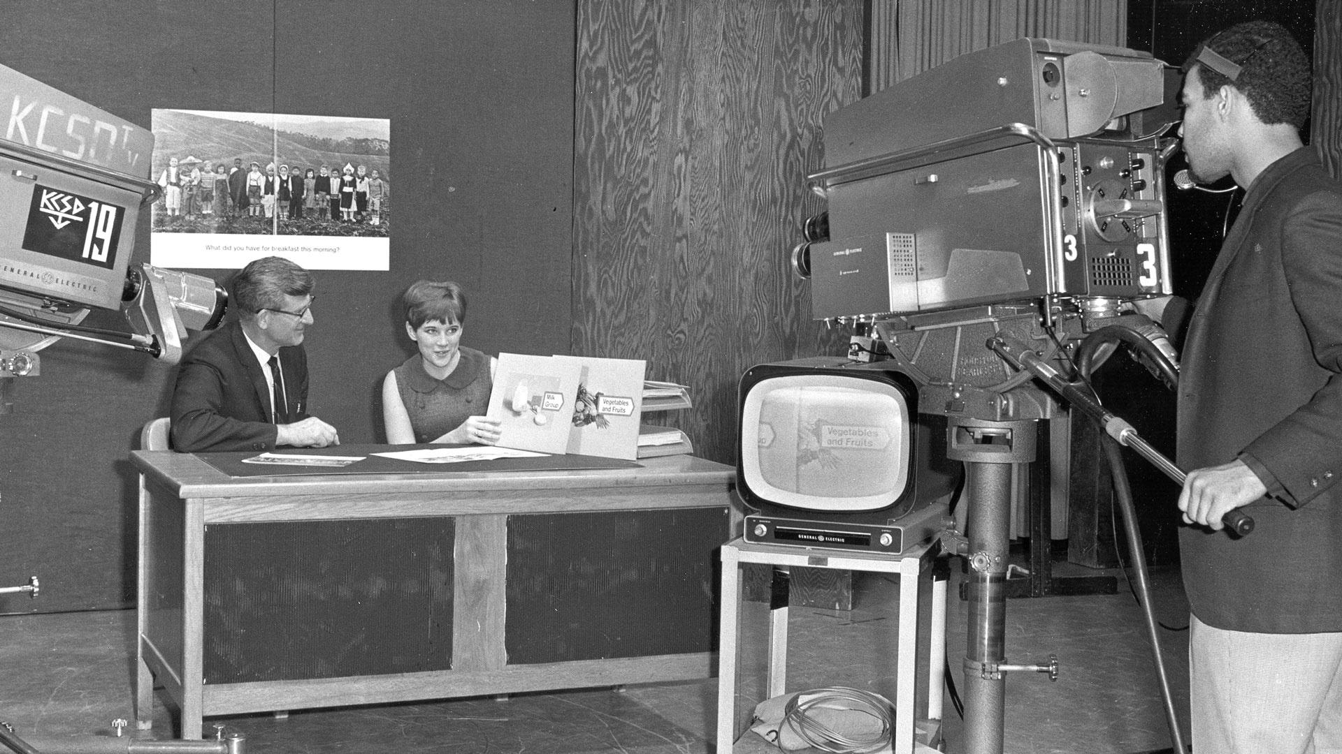 Man and woman with book and TV camera operator vintage photo