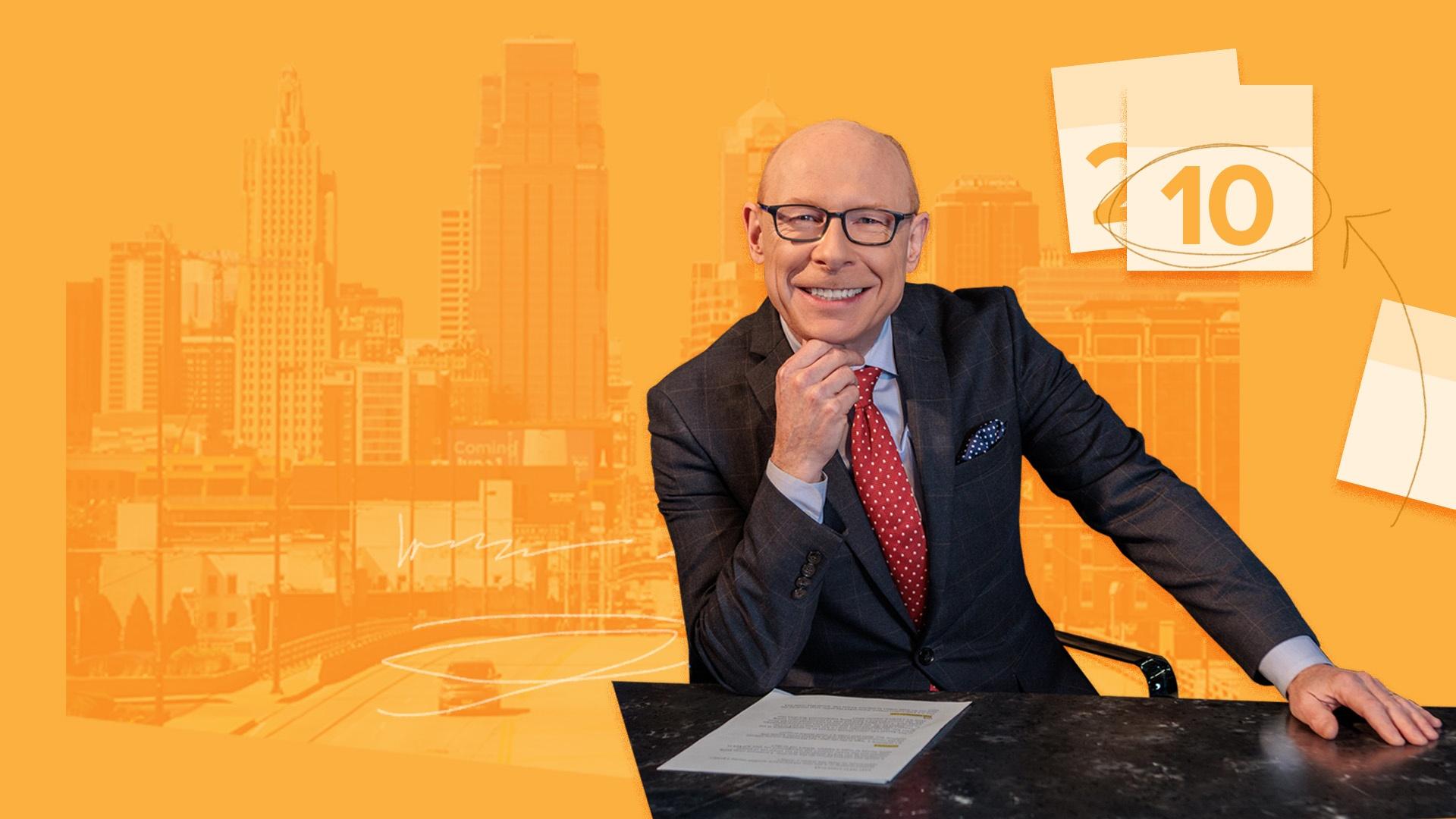 Nick Haines at desk with orange-toned KC Skyline and calendar pages in background