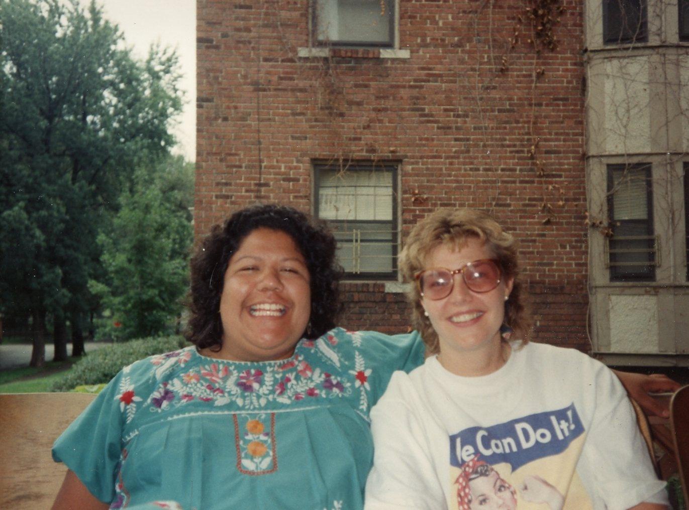 Two women smiling, one with arm around the other