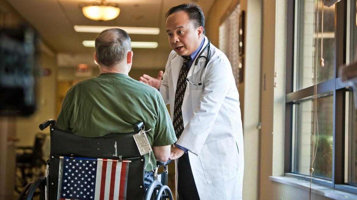 Man in wheelchair consulting with doctor.