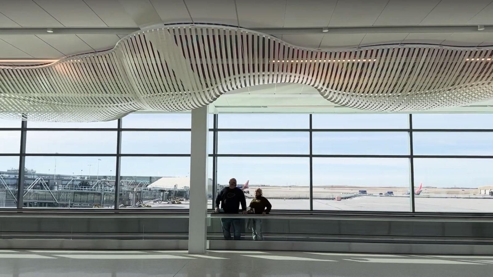 KCI terminal interior with art and passengers at window