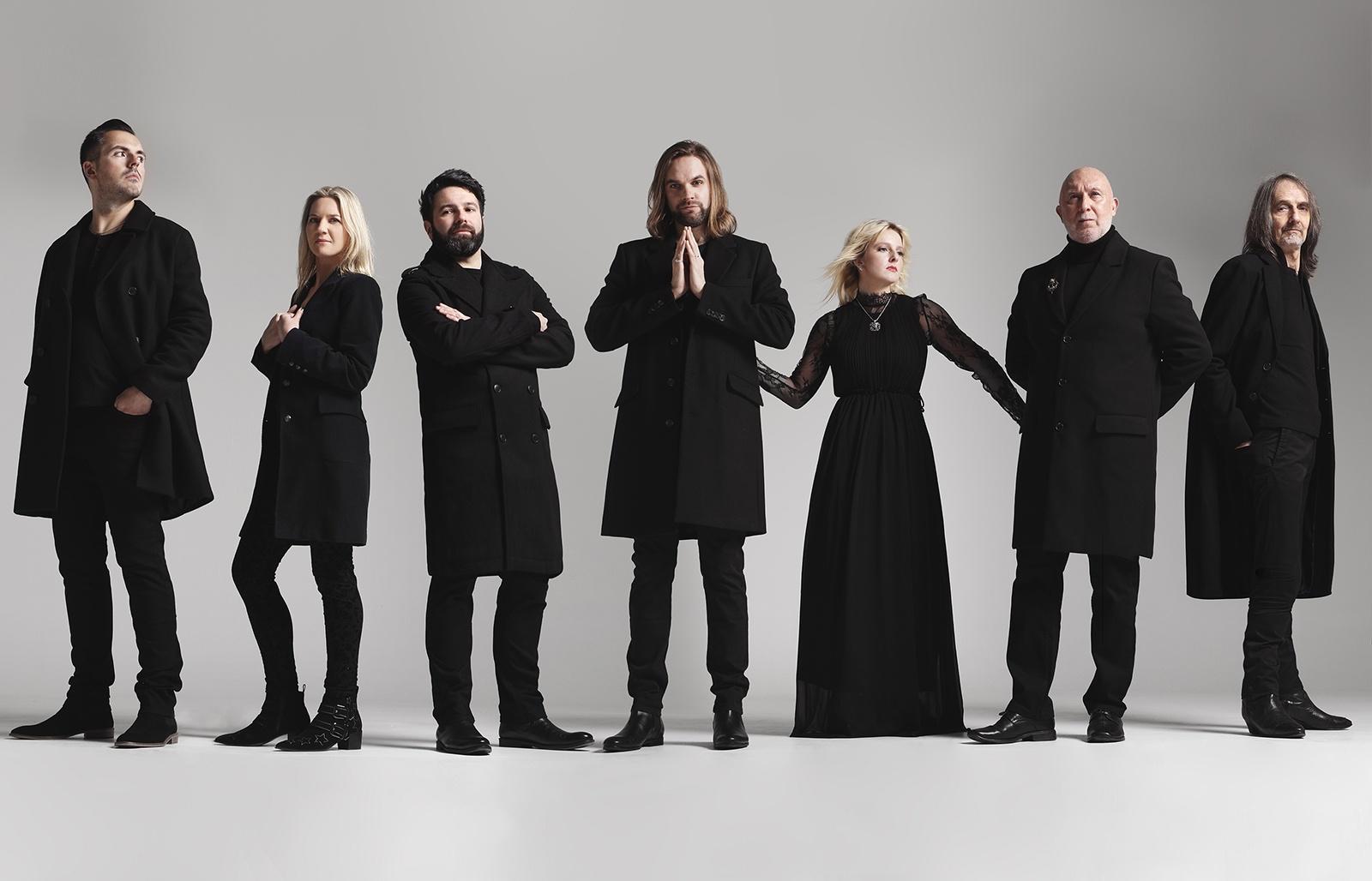 Band members dressed in black in various poses on gray background
