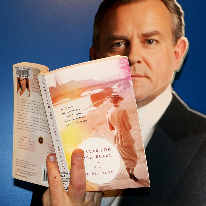 Board cutout of Lord Grantham from show Downton Abbey holding recommended book "A Star for Mrs. Blake"