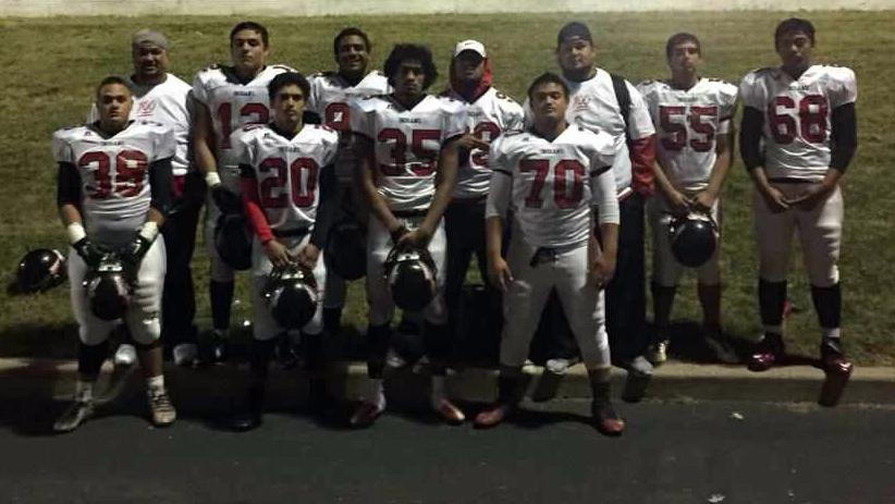 Players on a football team pose for a picture after a game
